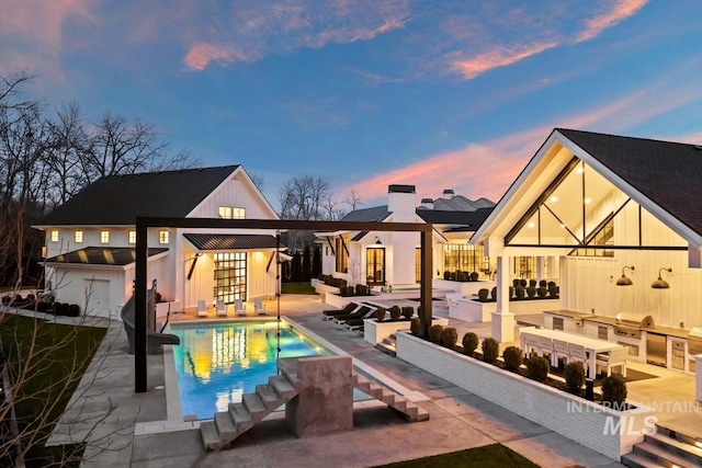 back house at dusk featuring a patio area