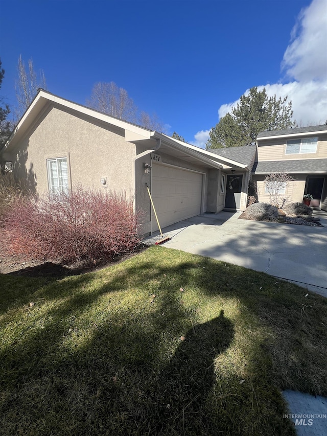 view of property exterior featuring a garage, a yard, stucco siding, and concrete driveway
