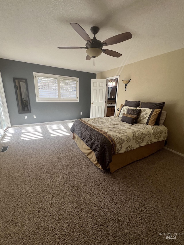 carpeted bedroom featuring ceiling fan, visible vents, and baseboards
