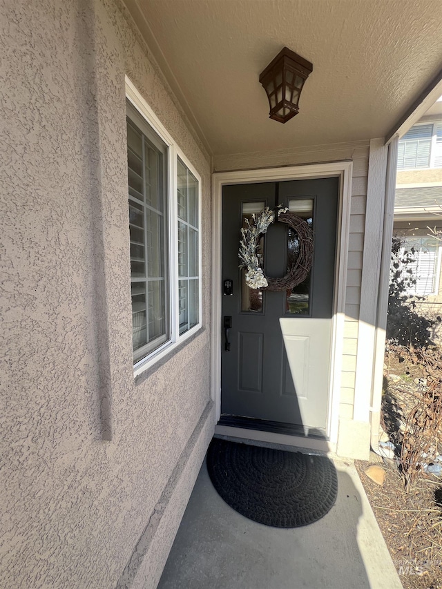 doorway to property featuring stucco siding