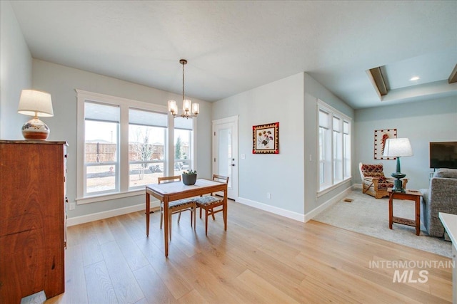 dining area with baseboards, an inviting chandelier, recessed lighting, and light wood-type flooring