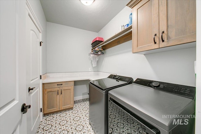 laundry area with washing machine and clothes dryer, cabinet space, and light floors