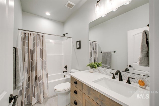 bathroom with visible vents, toilet, shower / tub combo, and vanity