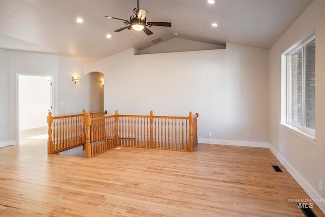 unfurnished room with ceiling fan, light hardwood / wood-style floors, and lofted ceiling