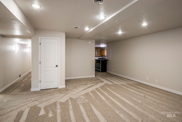 basement with light colored carpet and a textured ceiling