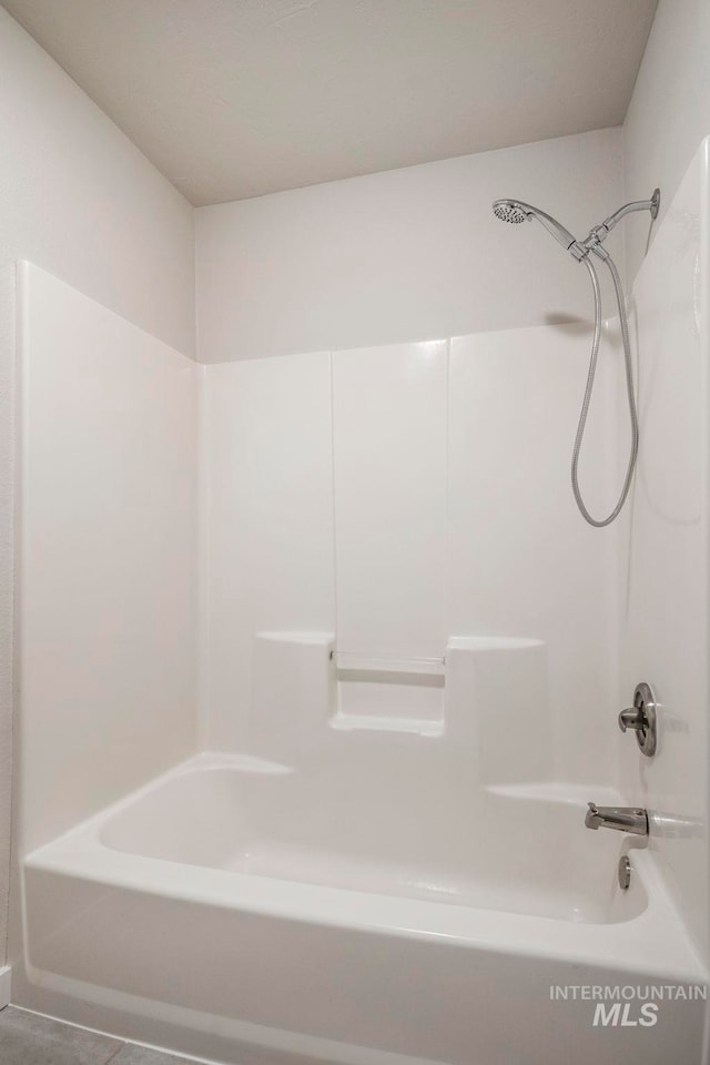 bathroom featuring tile patterned flooring and  shower combination