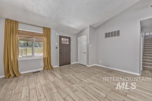 4610 Power Rd, Ontario, OR 97914 - foyer entrance with vaulted ceiling, light wood-type flooring, stairs, baseboards, and a textured ceiling