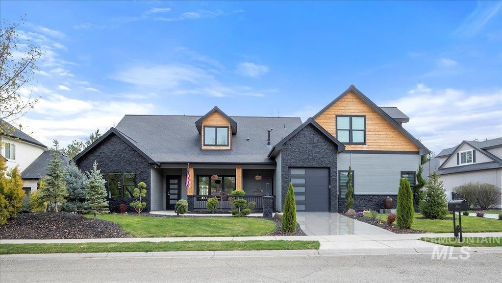 3054 S Bear Claw Way, Meridian, ID 83642 - view of front of property featuring concrete driveway, stone siding, an attached garage, a front lawn, and a porch