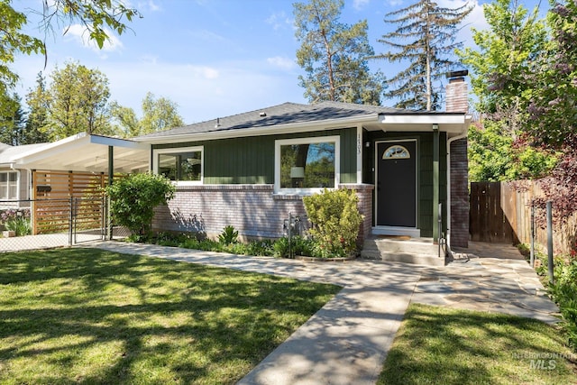 view of front of home featuring a gate, brick siding, a chimney, board and batten siding, and roof with shingles