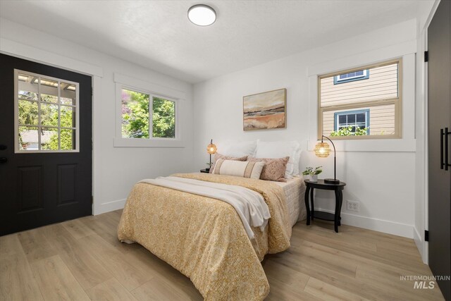 bedroom with light wood-style floors and baseboards