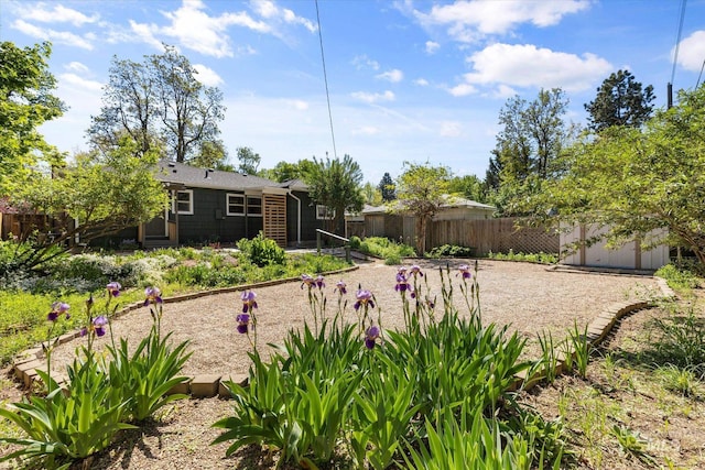 view of yard with fence, an outbuilding, and a storage unit