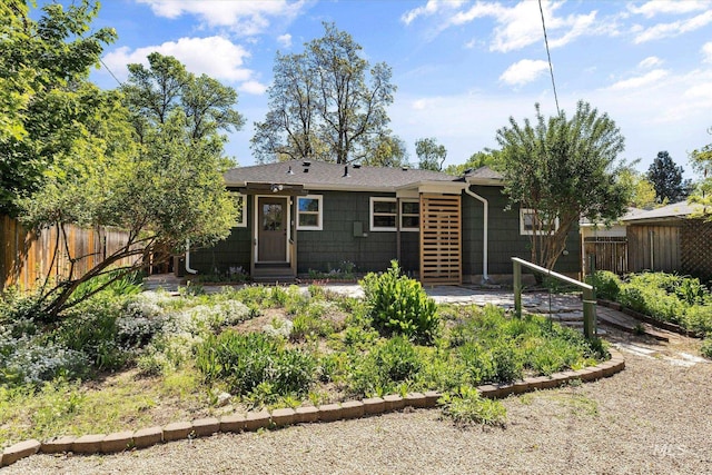 rear view of house with fence and entry steps