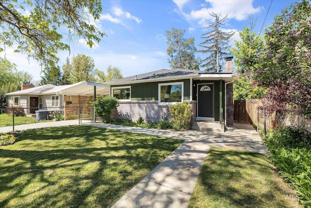 view of front of home featuring a chimney, brick siding, and a gate
