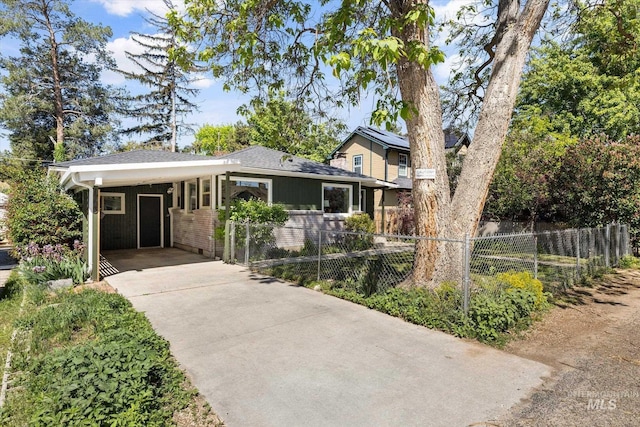 view of front of property featuring concrete driveway, an attached carport, brick siding, and a shingled roof