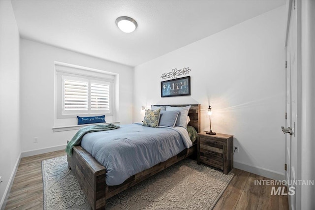 bedroom with wood finished floors and baseboards