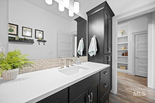 bathroom with backsplash, wood finished floors, and vanity