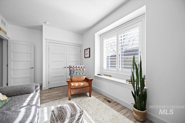 living area with baseboards and light wood finished floors