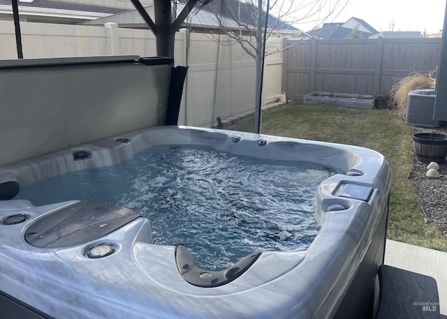 view of pool with central AC, a fenced backyard, and a hot tub