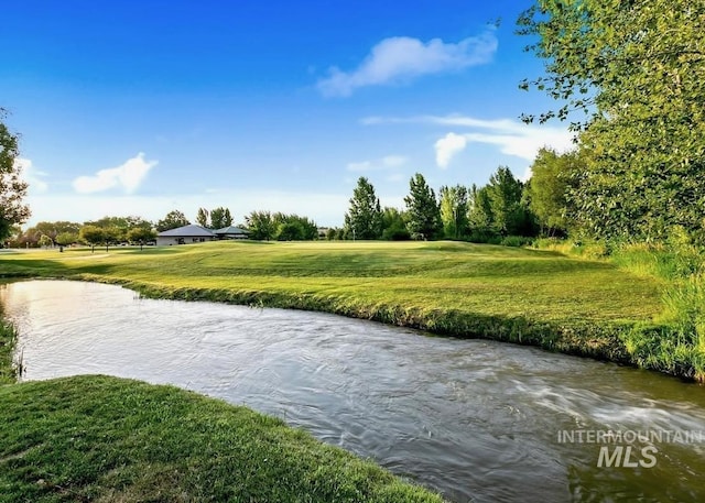 view of property's community with a water view and a yard