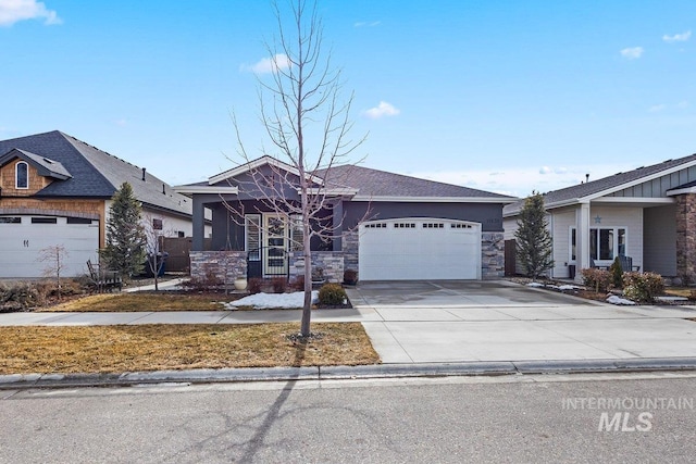 view of front of property featuring a garage, stone siding, and driveway