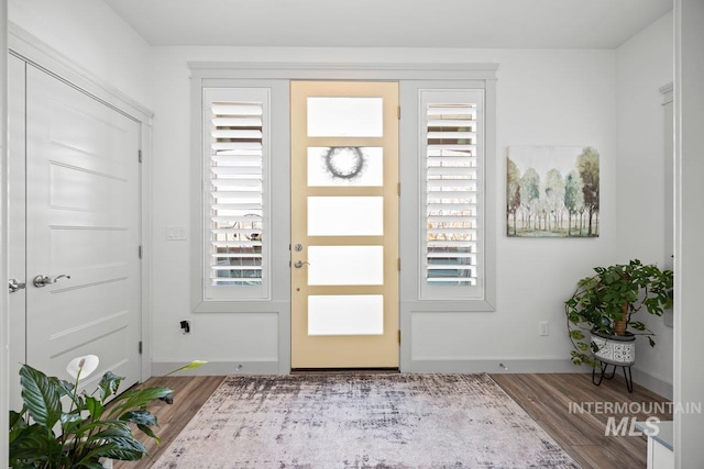 foyer entrance with baseboards and wood finished floors