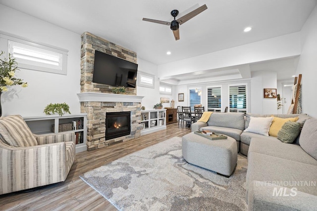 living room with a fireplace, a ceiling fan, wood finished floors, and recessed lighting