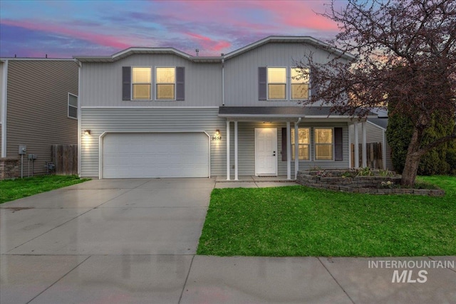 traditional-style home featuring a front yard, an attached garage, and driveway