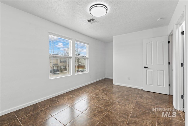 unfurnished bedroom with visible vents, a textured ceiling, and baseboards