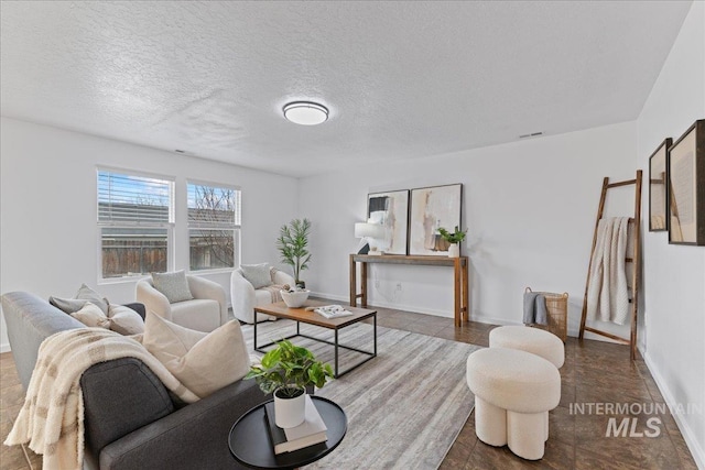 tiled living area featuring baseboards and a textured ceiling