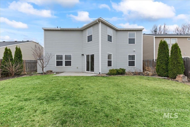 rear view of house featuring a patio, a lawn, and fence