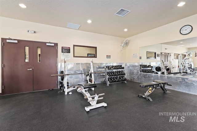 gym with recessed lighting, visible vents, and a textured ceiling