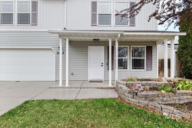 view of front of property with a porch, driveway, and a garage