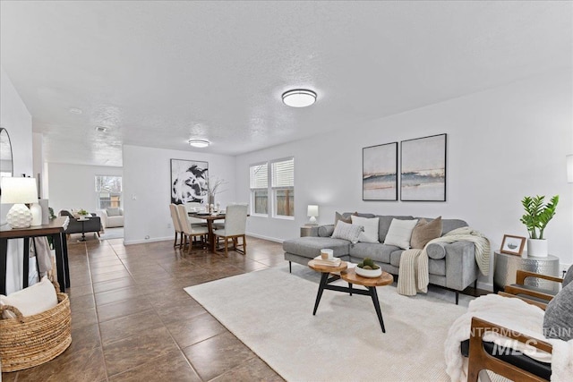 living room with a wealth of natural light, baseboards, and a textured ceiling