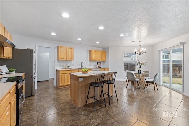 kitchen featuring a sink, double oven range, a kitchen island, light countertops, and a chandelier