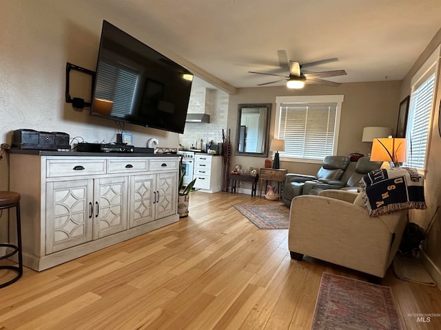 living room with light wood-type flooring and ceiling fan