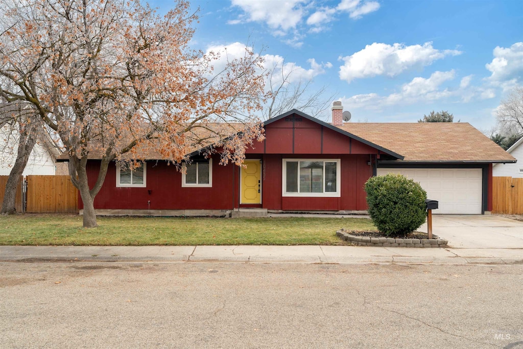 ranch-style home featuring a garage and a front lawn