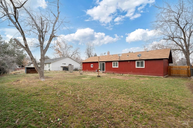 rear view of property featuring a lawn