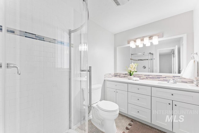 full bath with vanity, a stall shower, and toilet
