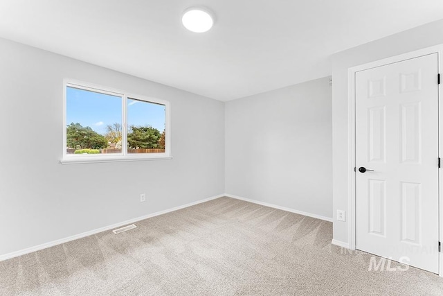 unfurnished room with carpet flooring, baseboards, and visible vents