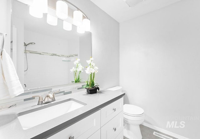 full bathroom featuring toilet, walk in shower, visible vents, and vanity