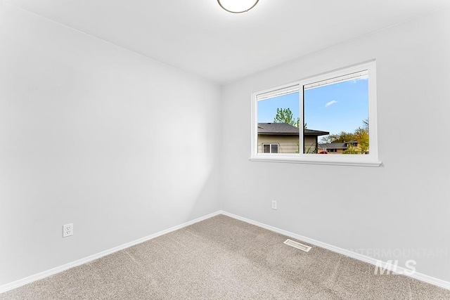 unfurnished room with carpet floors, baseboards, and visible vents