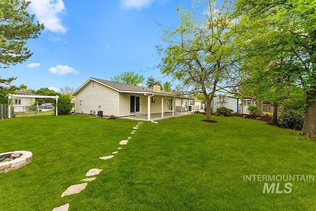 view of yard with a patio area, fence, and an outdoor fire pit