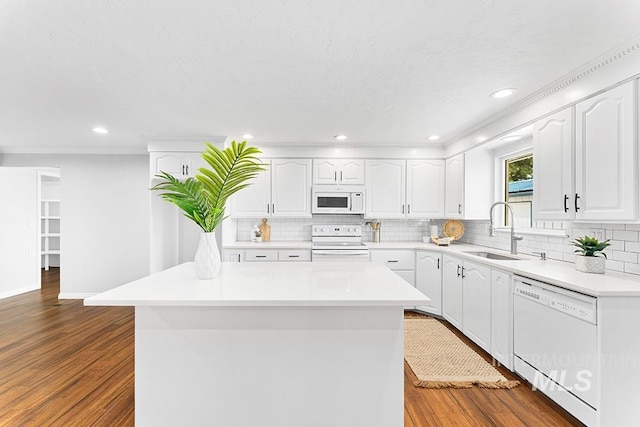 kitchen featuring white appliances, decorative backsplash, dark wood-style floors, and a sink