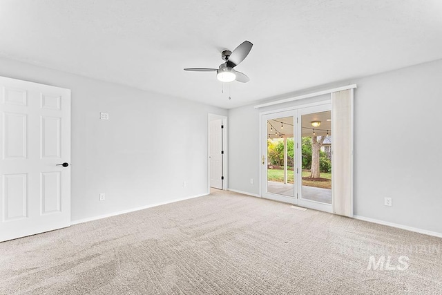 empty room featuring carpet flooring, a ceiling fan, and baseboards