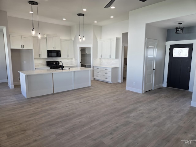 531 Full Moon Way, Twin Falls, ID 83301 - kitchen with black microwave, stove, white cabinets, tasteful backsplash, and a high ceiling