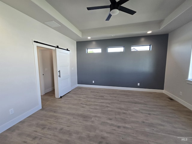 531 Full Moon Way, Twin Falls, ID 83301 - spare room featuring a barn door, recessed lighting, ceiling fan, a tray ceiling, and wood finished floors