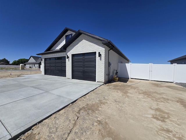 531 Full Moon Way, Twin Falls, ID 83301 - view of side of home with a garage, brick siding, a gate, and driveway