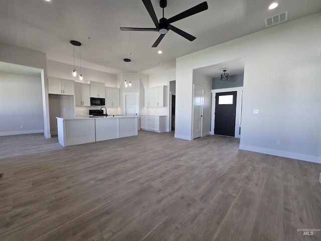 531 Full Moon Way, Twin Falls, ID 83301 - kitchen with open floor plan, black microwave, white cabinetry, wood finished floors, and recessed lighting