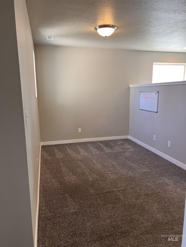 carpeted spare room featuring a textured ceiling