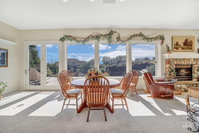 dining space with light colored carpet and a fireplace